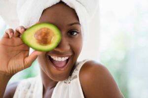 weight loss concept - Black woman holding sliced avocado